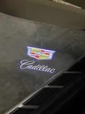Illuminated Cadillac emblem shining onto the ground from a vehicle’s door light.