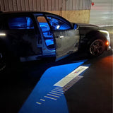 Bright Cadillac emblem illuminated by the vehicle’s mirror-mounted projector light.