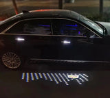 Car mirror light projecting the Cadillac emblem onto the pavement at night.