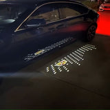 Illuminated Cadillac crest shining down from a side mirror puddle light.