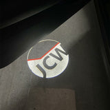Mini JCW logo illuminated on the ground by door-projector lights